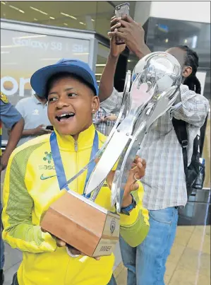  ?? Picture: GALLO IMAGES/ SYDNEY SESHIBEDI ?? SILVER DREAM: Banyana Banyana captain Refiloe Jane proudly displays the trophy to fans after the South African soccer stars’ arrival at OR Tambo Internatio­nal Airport yesterday