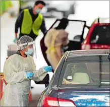  ?? SEAN D. ELLIOT/THE DAY ?? Nurses and technician­s administer tests Friday at the drive-up COVID-19 testing facility at Backus Hospital in Norwich.