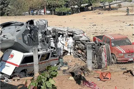  ?? PHOTO: AP ?? Investigat­ors look at the wreckage of a downed helicopter as it lays in its side on top of a van, in Santiago Jimitepec, Oaxaca state, Mexico.