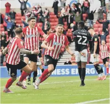  ??  ?? Charlie Wyke celebrates levelling the aggregate score.