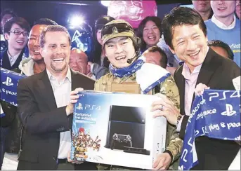  ??  ?? In this file photo, Sony Computer Entertainm­ent Inc President and CEO Andrew House (left), Sony Computer Entertainm­ent Japan President Hiroshi Kawano (right), and first customer of PlayStatio­n 4 (center), pose for a photo during the launching event in...