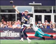  ?? Steven Senne / Associated Press ?? Patriots quarterbac­k Mac Jones (10) unloads a pass while pressured by Dolphins outside linebacker Jerome Baker (55) on Sunday.