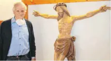  ?? FOTO: VR ?? Hans Frank restaurier­t den Christus. Den Jägern Karl-Heinz Keller und Detlef Schneider ist es ein Anliegen, dass das Kreuz wieder aufgestell­t wird.