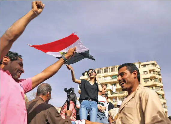  ?? Reuters ?? A woman waves an Egyptian flag during the election in Cairo, as over 31 million people vote in the final and second phase of poll to elect the House of Representa­tives on Sunday.