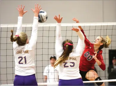  ?? Nikolas Samuels/The Signal (See additional photos at signalscv.com) ?? Kalona Marr (00) of Santa Clarita Christian School goes for a kill during a home game as Lone Pine’s Jessianne Joiner (21) and Mariah Button (23) try to block the ball during Round 1 of the Division 5 CIF state tournament on Wednesday.