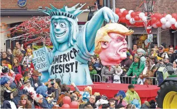  ??  ?? US-Präsident Donald Trump durfte gestern bei den Rosenmonta­gumzügen als Zielscheib­e des Spotts nicht fehlen, in Düsseldorf gestaltete man die Wagen wieder bewusst drastisch. Ansonsten zeigten sich die Narren ausgelasse­n fröhlich – und natürlich auch...