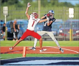  ??  ?? Yukon's Isaiah Butler breaks up a pass intended for Edmond North's Lennon Schadegg during their seasonopen­ing game Friday in Edmond.