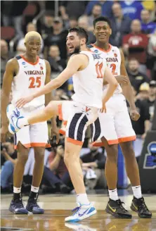  ?? Timothy D. Easley / Associated Press ?? Virginia's Ty Jerome (11) celebrates with teammates Mamadi Diakite (25) and De'Andre Hunter (12) after defeating Purdue.