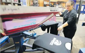  ?? NICK BRANCACCIO ?? Sherry Renaud of Hogan’s Printing produces sporting apparel on a printer at the company’s temporary home at 1636 Tecumseh Rd. East. Jeff Casey, publisher of snapd Windsor, donated the new space.