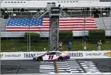  ?? MATT SLOCUM — THE ASSOCIATED PRESS ?? Denny Hamlin gets the checkered flag as he crosses the finish line to win the NASCAR Cup Series auto race at Pocono Raceway, Sunday in Long Pond, Pa.