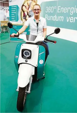  ??  ?? Die E-Schwalbe ist derzeit auch in Erfurt zu sehen. Carolin Hoffmann von den Stadtwerke­n Erfurt posiert hier bei der Messe „Haus.Bau.Ambiente“. Foto: Bodo Schackow, dpa