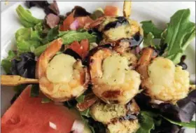  ?? JANET PODOLAK — THE NEWS-HERALD ?? Skewered shrimp wrapped around scallops and placed atop fresh greens was the luncheon salad one day aboard the train.