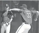  ?? ROB SCHUMACHER/AZCENTRAL SPORTS ?? Diamondbac­ks manager Torey Lovullo (left) watches pitcher Jake Barrett at spring training camp on March 21 at Salt River Fields. Barrett has been battling shoulder stiffness.