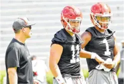  ?? STEVEN COLQUITT/GEORGIA PHOTO ?? Georgia quarterbac­ks coach James Coley visits with sophomore Jake Fromm (11) and freshman Justin Fields during a practice earlier this month at Sanford Stadium.