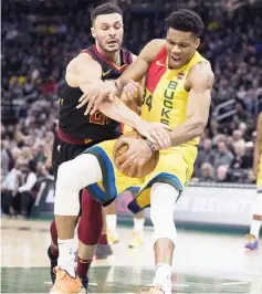  ??  ?? Cleveland Cavaliers forward Larry Nance Jr. (left) pressures Milwaukee Bucks forward Giannis Antetokoun­mpo during the third quarter at Fiserv Forum. — USA TODAY Sports photo