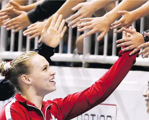 ?? VERONICA HENRI / TORONTO SUN / POSTMEDIA NETWORK ?? Ellie Black high-fives spectators after winning gold for her performanc­e in the floor routine and the balance beam on Wednesday in Toronto.