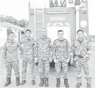  ??  ?? ARSAD (kanan) bersama anggota Bomba dan Penyelamat Sandakan yang membantu menjayakan perkhemaha­n itu.