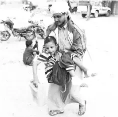  ??  ?? Abdulwahab Ali carries his nephew,Yahya Muhammad, who survived last month’s air strike that killed dozens of people including children, in Saada,Yemen. — Reuters photo