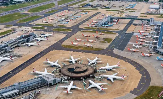  ??  ?? Grounded: Scores of planes stand idle at the usually thriving hub, a symbol of the catastroph­e besetting UK tourism