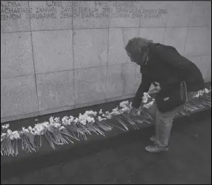  ?? ASSOCIATED PRESS ?? A woman places a yellow tulip at “The Umschlagpl­atz” monument Wednesday during personal unofficial observance­s marking the 80th anniversar­y of the Warsaw Ghetto Uprising in Warsaw, Poland.