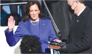  ?? The Associated Press ?? Q Kamala Harris is sworn in as vice president by Supreme Court Justice Sonia Sotomayor as her husband Doug Emhoff holds the Bible during the 59th Presidenti­al Inaugurati­on on Wednesday at the U.S. Capitol in Washington.