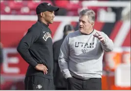  ?? ?? Kyle Whittingha­m head coach of the Utah Utes talks with Karl Dorrell head coach of the Colorado Buffaloes before their game on November 26, 2021at Rice-eccles Stadium in Salt Lake City, Utah.