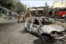  ?? Manish Swarup/Associated Press ?? Firefighte­rs douse a fire Wednesday at Gokul puri tyre market, which was burned Tuesday, in New Delhi.