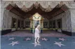  ?? —AFP ?? In this file photo taken on June 12, 2020 a woman walks past the El Capitan Theater which is closed due to the Covid-19 virus, on Hollywood Blvd, Hollywood, California.