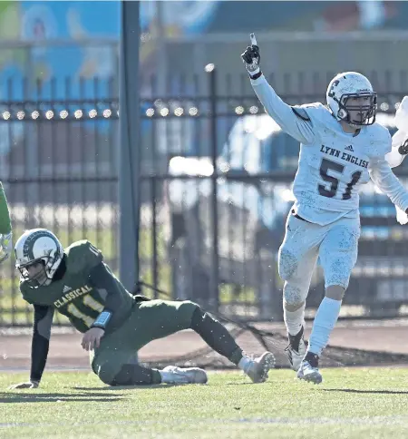  ?? CHRISTOPHE­R EVANS / BOSTON HERALD ?? BIG D: Lynn English teammates Tommy Gaylord (51) and Alex Garcia celebrate after a fumble recovery in the Bulldogs’ 12-0 shutout of Lynn Classical yesterday.