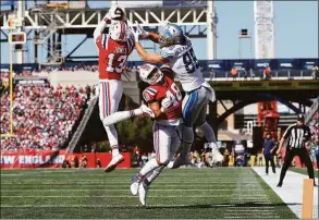  ?? Michael Dwyer / Associated Press ?? Patriots cornerback Jack Jones (13) intercepts a pass intended for Lions tight end T.J. Hockenson as Patriots linebacker Jahlani Tavai (48) defends during the first half on Sunday in Foxborough, Mass.