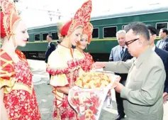  ?? — AFP photo ?? File photo shows Kim Jong Il being welcomed by Russian women in traditiona­l dress at the Bureya station in Russia’s Amur region on August 21, 2011.