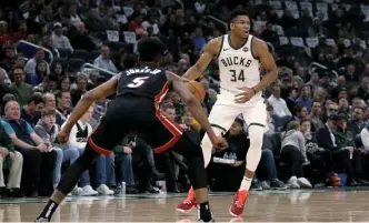  ?? GETTY IMAGES ?? WATCH OUT: Milwaukee’s Giannis Antetokoun­mpo looks to make a move against Miami’s Derrick Jones during last night’s game.