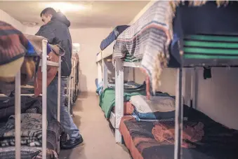  ??  ?? An adult recovering methamphet­amine addict fixes his bed in the crowded sleeping quarters at the Volver a Vivir recovery center.