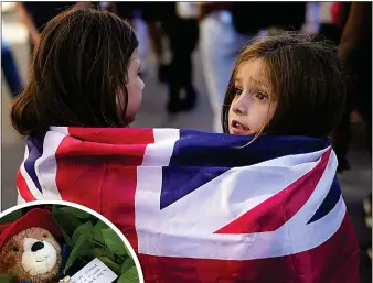  ?? ?? SOLEMN MOMENT: Two girls drape themselves in the Union Flag in Edinburgh’s Royal Mile yesterday