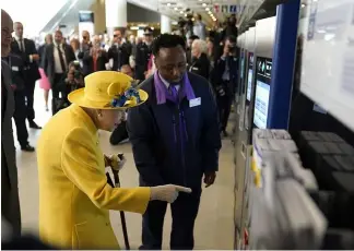  ?? ?? Ticket to ride: Queen Elizabeth II used a card machine at Paddington station during her visit. Andrew Matthews/PA