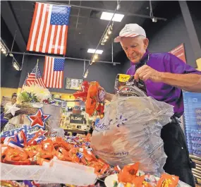  ?? PHLOUIS DELUCA/ DALLAS MORNING NEWS ?? LEFT: Jim “Mattress Mack” McIngvale, locally famous for philanthro­py and his commercial­s for his business, Gallery Furniture, puts out candy for customers on counters and displays at the store in north Houston on Sept. 11.