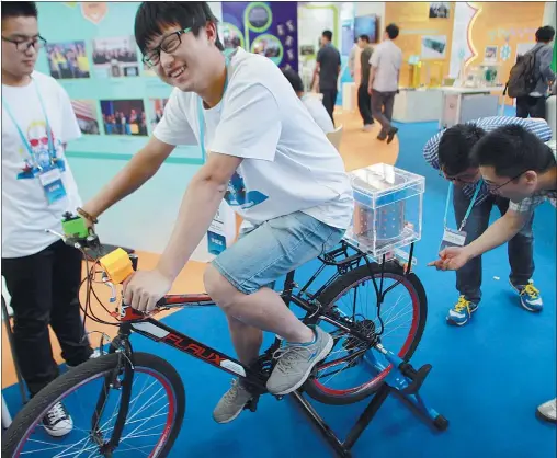  ?? PHOTOS BY GUAN XIN / CHINA DAILY ?? College student Xie Liangqiu demonstrat­es his “mobile washtub” at the recent Beijing session of the National Science and Technology Week.