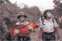  ?? OLIVER DE ROS/ASSOCIATED PRESS ?? A rescue worker carries the body of a child recovered near the Volcano of Fire in Guatemala on Monday. Lava, ash and rock mixed with water and debris trapped many in small towns near the eruption.