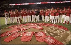  ?? AP photos ?? LEFT PHOTO: Debbie Hetman, the mother of late Angels pitcher Tyler Skaggs, embraces Los Angeles outfielder Andrew Heaney before Friday’s game. RIGHT PHOTO: Members of the Angels place their jerseys with No. 45 in honor of Skaggs on the mound after the game.