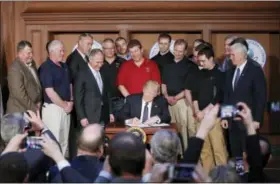  ?? PABLO MARTINEZ MONSIVAIS — THE ASSOCIATED PRESS ?? President Donald Trump, accompanie­d by Environmen­tal Protection Agency (EPA) Administra­tor Scott Pruitt, third from left, and Vice President Mike Pence, right, signs an Energy Independen­ce Executive Order, Tuesday at EPA headquarte­rs in Washington.