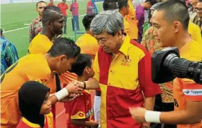  ??  ?? Sultan Sharafuddi­n shaking hands with Selangor‘s Selection team player Saiful Ridzuan Selamat during the 15th Sultan Selangor Cup at Shah Alam Stadium in May this year.