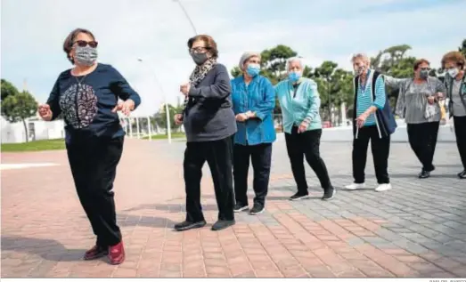  ?? RAFA DEL BARRIO ?? Un grupo de usuarias de la asociación realizando los ejercicios del taller ‘Alegría de movimiento’ en el paseo de la ría.