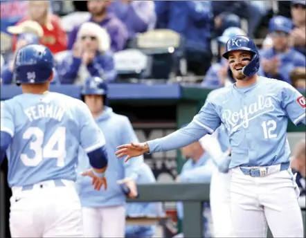  ?? AP photo ?? Kansas City’s Nick Loftin (12) reacts as Freddy Fermin (34) scores off a hit by Maikel Garcia during the first inning of a game against Houston on Thursday in Kansas City, Mo.