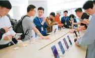  ?? Photo: Reuters ?? Customers check out Huawei’s Pura 70 series smartphone­s at the company’s flagship store in Beijing.