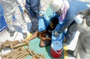  ?? AP ?? Aldi Novel Adilang, 18, sits on the deck of a Panamanian-flagged vessel, MV Arpeggio after being rescued in the waters near Guam.