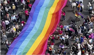  ?? ?? People hold a rainbow   ag as they attend the 45th Berlin Pride Parade for Christophe­r Street Day (CSD) in Berlin, Germany.