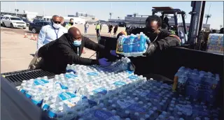  ?? Justin Sullivan / Getty Images ?? Volunteers load cases of water into the bed of a truck during a mass water distributi­on at Delmar Stadium on Friday in Houston. Much of Texas is still struggling with historic cold weather, power outages and a shortage of potable water after a winter storm swept across 26 states.