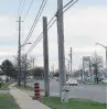  ??  ?? An old utility pole stands next to its replacemen­t on the East Mall, one of many that Toronto Hydro has not removed.