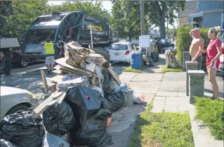  ?? EDUARDO MUNOZ ALVAREZ — ASSOCIATED PRESS ?? Residents wait while a worker picks up debris Sept. 6 from their flood damaged home in Passaic, NJ., in the aftermath of Hurricane Ida.