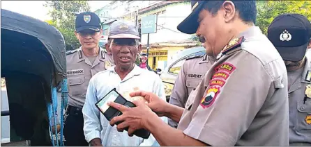  ??  ?? KAGET JADI SENANG: Kapolsek Pekalongan Timur Kompol Agus Riyanto memasukkan sejumlah uang ke dompet abang becak pada Operasi Dompet Ramadan. WAHYU HIDAYAT/RADAR PEKALONGAN/JPG